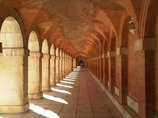 arched walkway with shadows red from reflected light